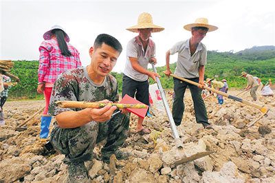 隋耀达在地里与村民研究如何种好牧草